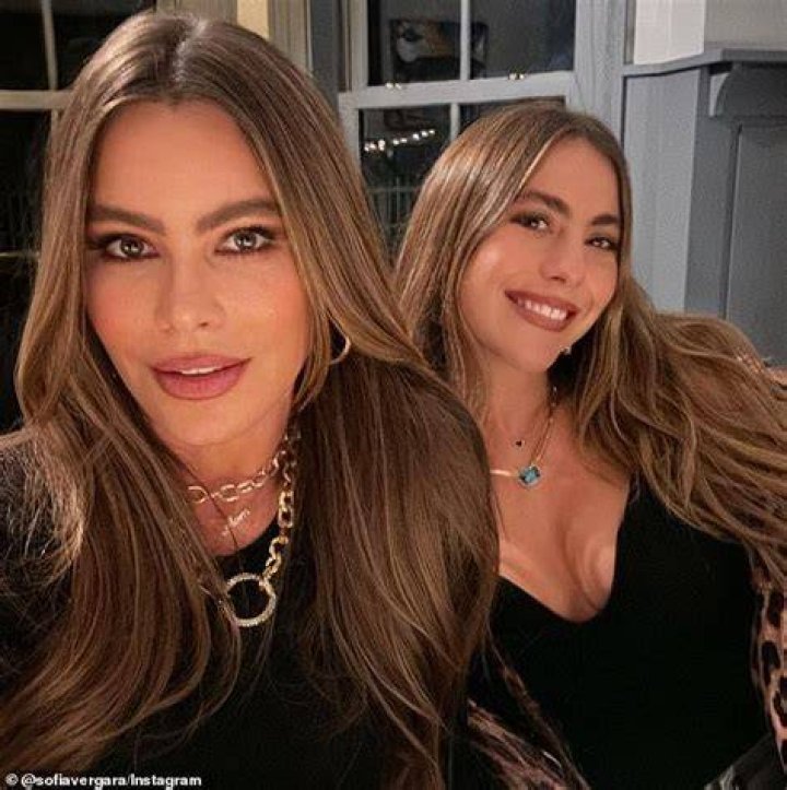 Photo posted by Sofia Vergara on Instagram August 2023 where she is wearing a strapless, hot pink swimsuit and a printed sarong, enjoying a glass of wine on a beach lounger by the pool.