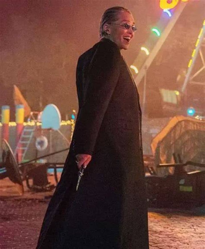 Sharon Stone in black coat with dragonfly brooch