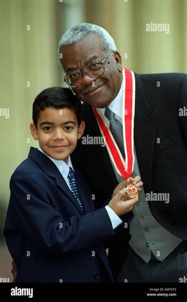 Sir Trevor McDonald with his family (L-R) son Tim, 32, son Jack, 10 and wife Josephine at Buckingham Palace on November 30, 1999. | Photo: Getty Images