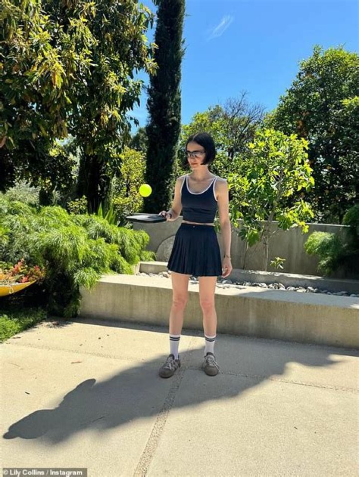 Toned: One snap saw her pose in leggings and a bralet with one of Lewis' trophies visible