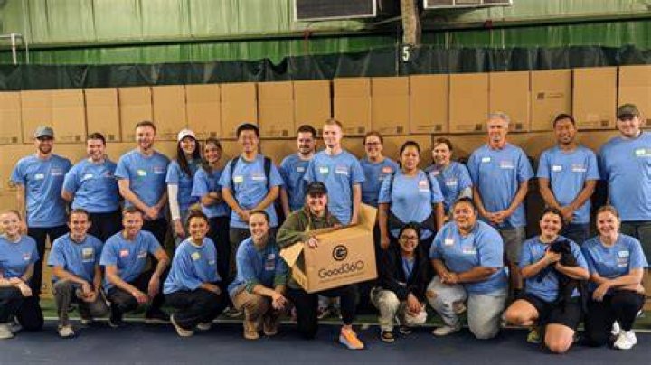 Volunteers stand with Good360 boxes at the Stock the Block service project.